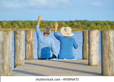 Loving elderly couple having a picnic in autumn at lake                                