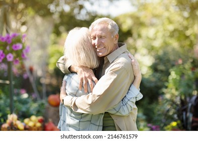 Loving elderly couple hugging each other during walk in their own garden in countyside, enjoying their vacation outdoors, copy space - Shutterstock ID 2146761579