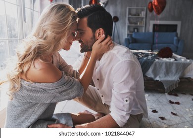 Loving everything about her. Beautiful young couple bonding and smiling while sitting in the bedroom - Shutterstock ID 1021844047