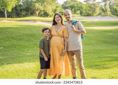 A loving family enjoying a leisurely walk in the park - a radiant pregnant woman after 40, embraced by her husband, and accompanied by their adult teenage son, savoring precious moments together - Shutterstock ID 2341473815