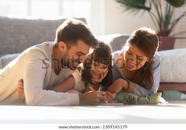 Loving family parents with cute child daughter enjoy drawing with