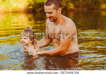 Loving father and child having fun upside down in the river