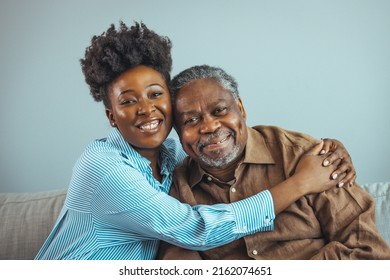 Loving father and daughter together on sofa. Beautiful woman with her father as they both smile. Beautiful young woman embracing her father. Senior African American man and daughter - Shutterstock ID 2162074651
