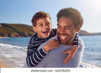 Loving Father Giving Son Piggyback As They Walk Along Winter Beach Together - Powered by Shutterstock