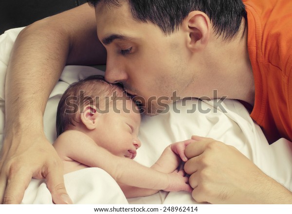 愛する父は生まれたばかりの赤ちゃんにキスをする 父は眠りながら手をつないでいる間に 子どもの額にキスをする 親の愛 の写真素材 今すぐ編集