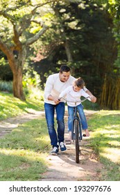 Loving Father Teaching Daughter To Ride Bike 