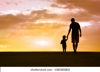 Loving father walking side by side with son holding hands. Fathers Day, and fatherhood concept. 