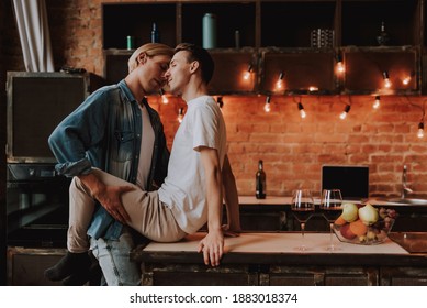 Loving Gay Couple At Home. Two Handsome Passionate Men Hugging And Kissing On Kitchen. LGBT Concept.