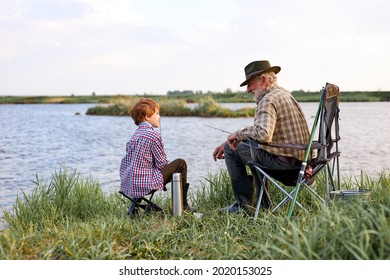 Loving Grandfather And Grandson Fishing Together During Camping Trip By Lake, Copy Space. Side View On Senior Male And Child Having Talk, Adult Man Teach To Fish, In Nature, Countryside