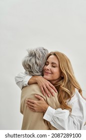 Loving grownup daughter hug embrace old mother feel grateful and thankful, isolated on white studio background. Caring adult child cuddle mature mom. Vertical narrow shot. Motherhood. - Shutterstock ID 2087289100