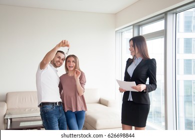 Loving happy couple just bought new dream home, starting family life, meeting with real estate agent and getting keys to own big flat, first property investment, mortgage for young family 