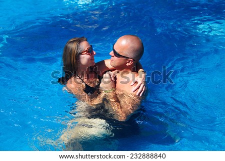 Loving happy couple in pool. Summer vacation.