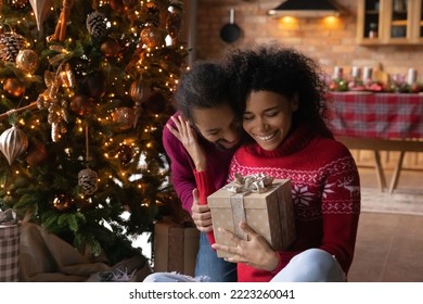 Loving happy young African American couple sit near fir tree exchange gifts on New Year at home. Smiling millennial biracial man and woman celebrate Christmas Eve together. Winter holiday concept. - Powered by Shutterstock