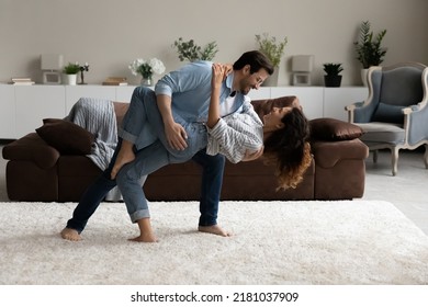 Loving Husband Dancing Tango With Lovely Wife, Standing Barefoot On Carpet In Modern Living Room With Fashionable Furniture, Full-length View. Wedding Dance Rehearsal, Hobby, Love, Celebration Concept