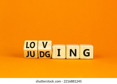 Loving Or Judging Symbol. Concept Words Loving Or Judging On Wooden Cubes. Beautiful Orange Table Orange Background. Business Loving Or Judging Concept. Copy Space.