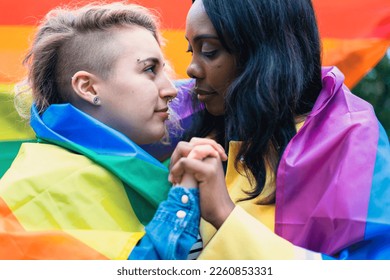 Loving lesbian couple holding hands and gazing into each other's eyes at a LGBTQ rights rally - A symbol of unity, love and acceptance. - Powered by Shutterstock