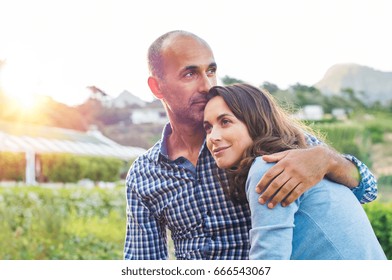 Loving Man And Happy Woman In A Spring Blooming Park. Happy Mature Couple In Love Embracing Outdoor. Hispanic Boyfriend Embracing Her Brunette Girlfriend During Sunset In A Summer Day.