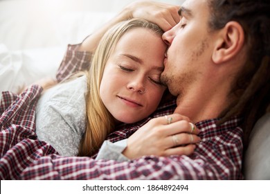 Loving Man Hugging Charming Girlfriend And Pressing Lips To Her Forehead While Taking Tap At Home