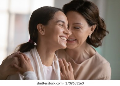 Loving Mature 60s Mother Hug Cuddle Happy Millennial Girl Child Enjoy Tender Intimate Close Family Moment At Home, Caring Middle-aged Mom Embrace Grownup Adult Daughter Relaxing Together