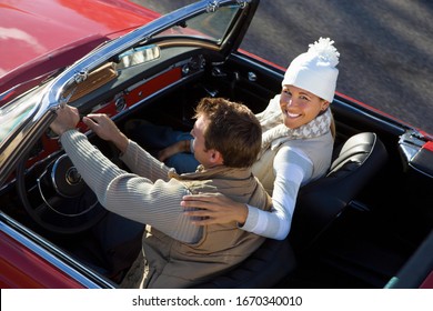 Loving Mature Couple Driving Classic Red Convertible Car On Road Trip