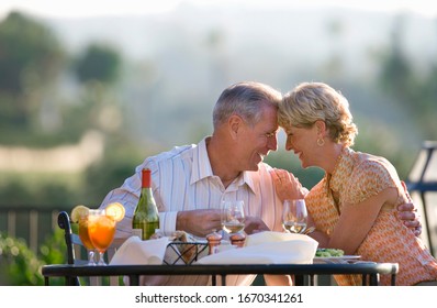 Loving mature couple eating at outdoor restaurant table - Shutterstock ID 1670341261