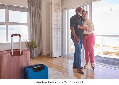 Loving Mature Couple With Luggage Arriving In Beachfront House Overlooking Ocean For Summer Vacation - Powered by Shutterstock