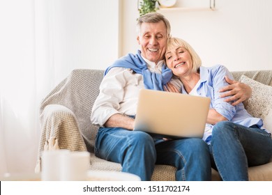 Loving Mature Couple Watching Film On Laptop Computer, Having Rest At Home, Free Space