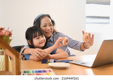 Loving Mature Grandma And Little Grandchild Having Video Call On Laptop Computer At Home Together. Multi Generational, Family And Love Concept