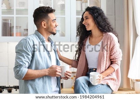 Loving Middle Eastern Couple Bonding While Drinking Coffee In Kitchen, Happy Millennial Arab Man And Woman Holding Cups With Hot Drinks And Enjoying Spending Time Together At Home, Closeup