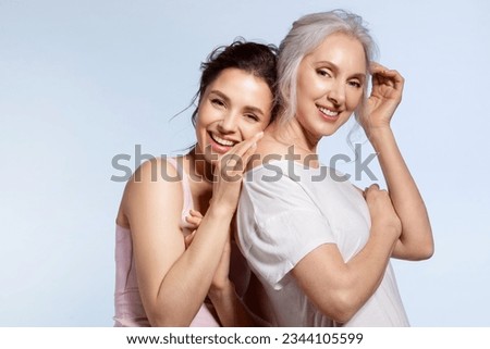 Loving millennial daughter and adorable senior mother Hugging in good mood studio portrait. Parent and adult child enjoying sweet tender moment, family pastime together. Overjoyed beautiful people