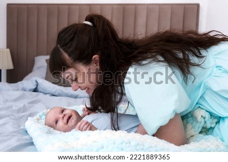 Similar – Relaxed mother and sons playing over the bed