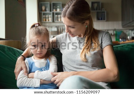 Loving mother consoling or trying make peace with insulted upset stubborn kid daughter avoiding talk, sad sulky resentful girl pouting ignoring caring mom embracing showing support to offended child
