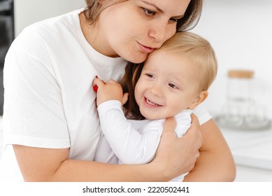 A Loving Mother Cuddling Her Baby At Home. A Vivid Portrait Of A Happy Mother, With Her Son. A Mother Hugging Her Young Child.