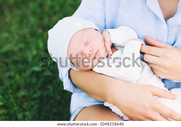 生まれたばかりの赤ん坊を抱いた愛する母親 自然の上で かわいく眠れる新生児を持つ美しい母親 赤ちゃんの生後1週間 幸せな母親と仲良しな家族 の写真素材 今すぐ編集