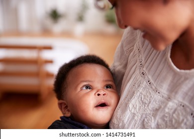 Loving Mother Holding Newborn Baby At Home In Loft Apartment