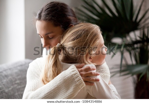 愛する母親が可愛い小さな女の子を抱きしめ 養子を抱きしめ 母と娘の愛情を込め 母と娘の愛情や愛情 養子縁組のコンセプトを持つ の写真素材 今すぐ編集