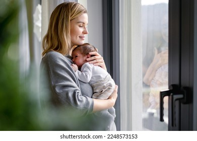 Loving mother hugs her little baby at home - Shutterstock ID 2248573153