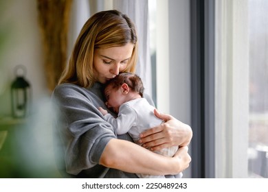 Loving mother hugs her little baby at home