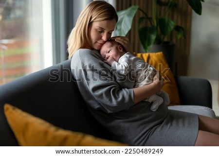 Similar – Mother giving bottle to her newborn