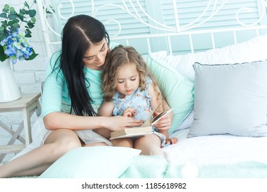 Loving Mother Reading A Goodnight Story To Her Child