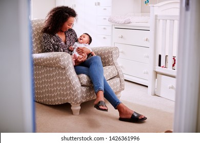 Loving Mother Sitting In Chair Cuddling Baby Son In Nursery At Home - Shutterstock ID 1426361996