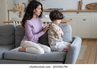 Loving mother trying to make peace with stubborn offended boy kid sitting frowning and with crossed arms ignoring caring mom. Mummy feeling sorry for misunderstanding with child. Parenthood problems - Powered by Shutterstock