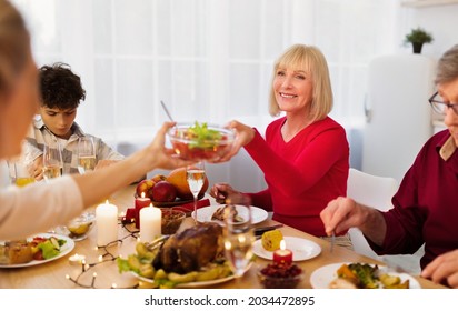 Loving Multi Generation Family Having Thanksgiving Or Christmas Dinner Together, Passing Food To Each Other, Enjoying Tasty Festive Meal At Home. Celebrating Holiday Concept