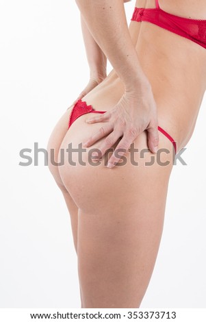 Loving my body. Side view of beautiful young woman in red posing against white background