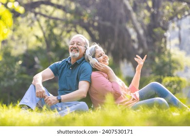 Loving old couple spending leisure time listening music during sunny day - Powered by Shutterstock