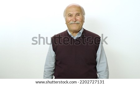 Loving old man looking at camera. Studio portrait of old man isolated on white background. Portrait of a thoughtless smiling neutral old man.