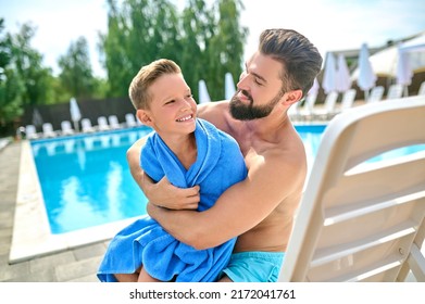 Loving Parent Embracing His Kid Wrapped In A Towel