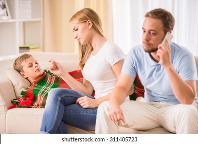 Loving parents take care of his son. Mother checking a temperature, father is calling to a doctor. - Powered by Shutterstock