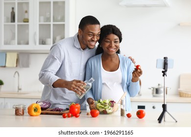 Loving Pregnant Black Family Broadcasting While Cooking Healthy Food At Home, Using Mobile Phone On Tripod. Cheerful Expecting African American Couple Having Cooking Lesson Online, Copy Space