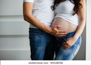 Loving pregnant couple holding the belly 